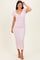 woman wearing a light pink puff sleeve midi dress with a ruched bodice and a fitted skirt