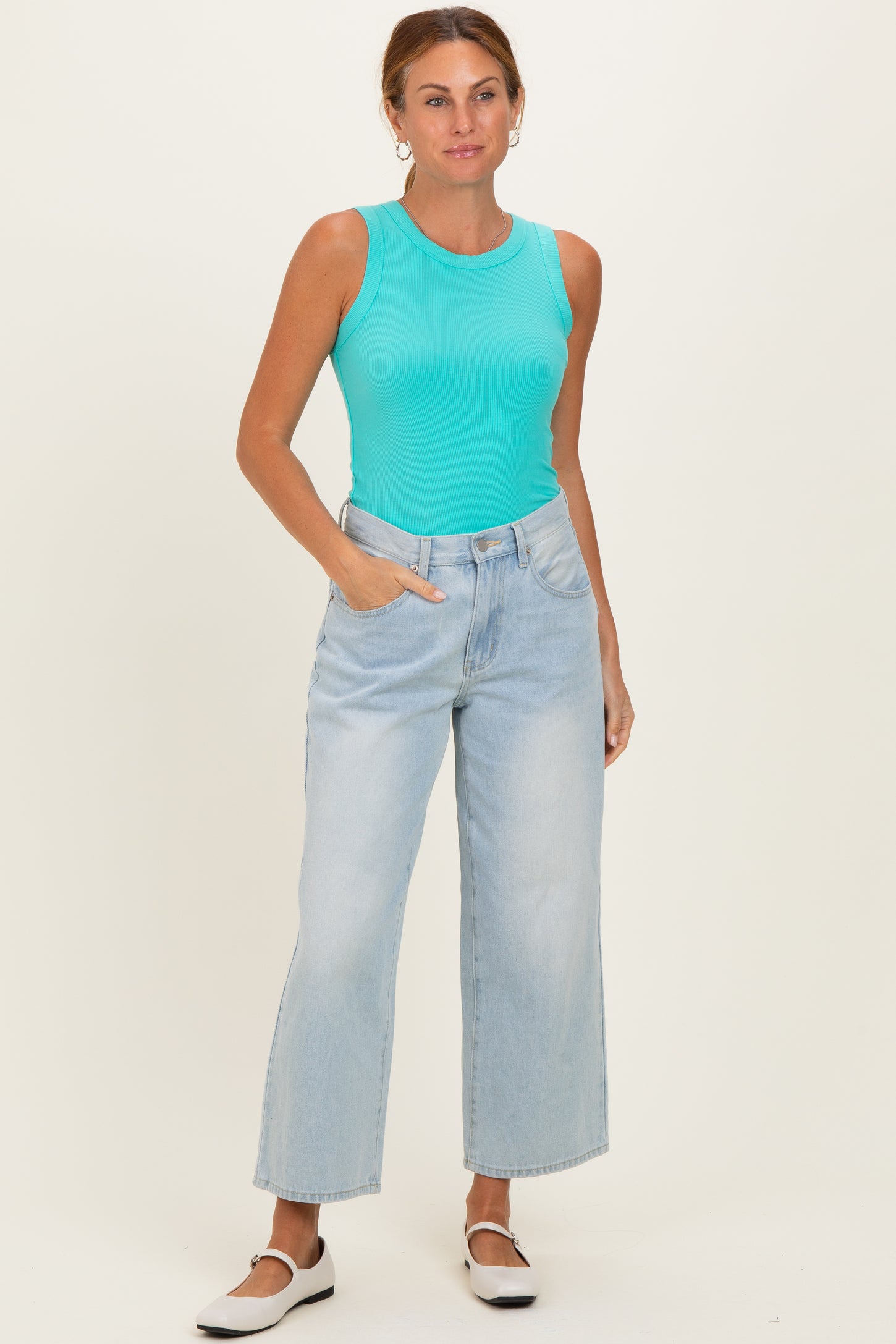 woman wearing a turquoise ribbed tank top and light wash wide-leg jeans with side pockets