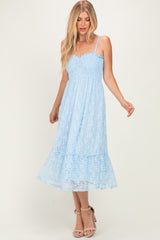 woman wearing a light blue lace midi dress with a scalloped neckline and ruffled hem, styled with strappy heels