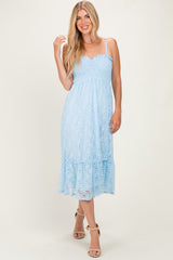 woman wearing a light blue lace midi dress with adjustable straps and a ruffled hem