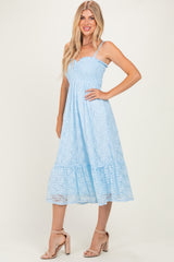 woman wearing a light blue lace midi dress with a smocked bodice and tiered skirt