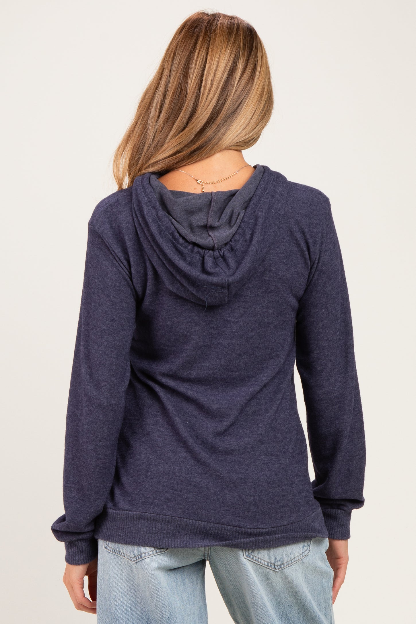 woman wearing a dark navy maternity hoodie with a relaxed fit and a hood, seen from the back