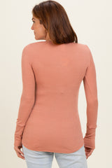 woman wearing a salmon long sleeve ribbed top, view from the back, paired with light denim jeans