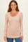 woman wearing a soft pink long sleeve ribbed henley top with buttons and a relaxed fit
