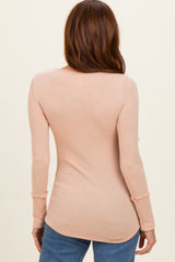 woman wearing a light pink ribbed long sleeve top, viewed from the back