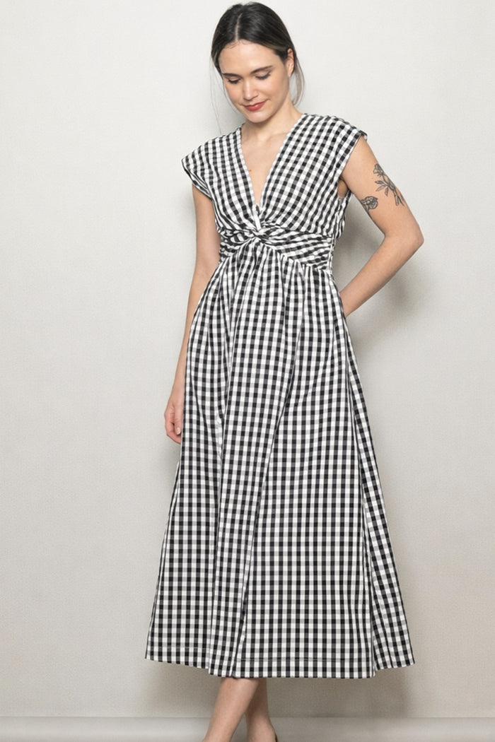woman wearing a black and white checkered maxi dress with a knotted front and cap sleeves