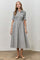 woman wearing a gray and white checked button-up dress with short sleeves and a gathered waist