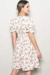 woman wearing a cream floral wrap dress with puff sleeves and a fitted waist, posed from the back