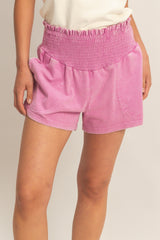 woman wearing pink smocked waist shorts with side pockets