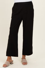 woman wearing black wide-leg trousers and beige slide sandals