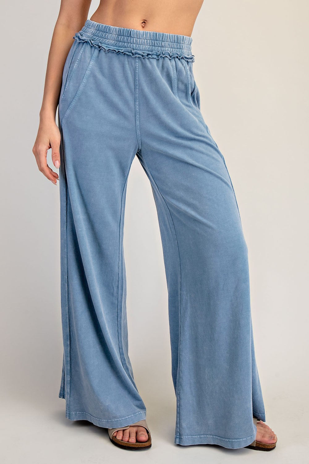 woman wearing light blue wide-leg lounge pants with an elastic waistband and side pockets