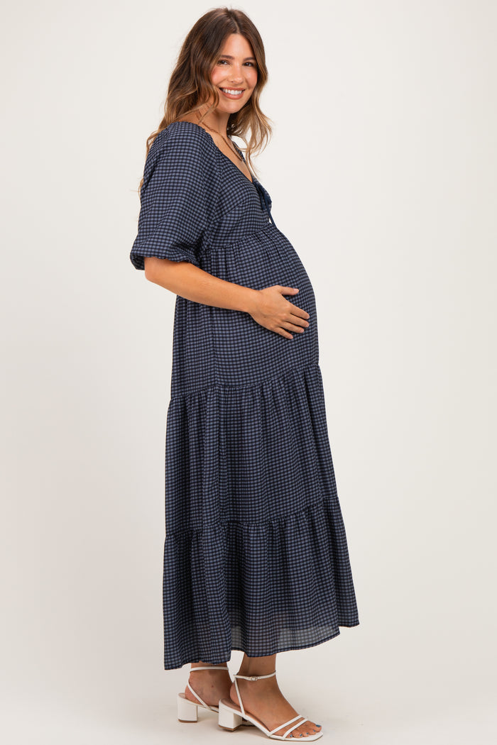 woman wearing a navy checkered maternity dress with tiered skirt and baby bump visible