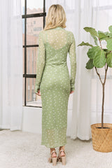 woman wearing a sheer green long sleeve dress with white polka dots, standing with her back to the camera