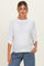 woman wearing a white short sleeve maternity sweater with relaxed fit and a visible baby bump