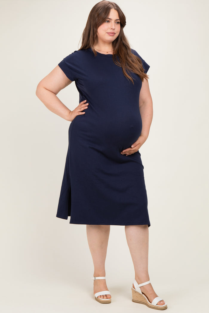 woman wearing a navy blue short sleeve maternity dress, showcasing her baby bump