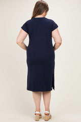woman wearing a dark navy maternity plus dress with short sleeves and a side slit, showing her back