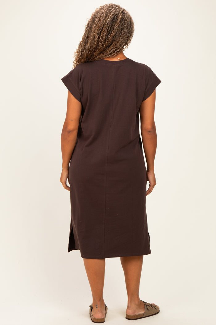 woman wearing a chocolate brown short sleeve plus size dress with side slits visible from the back