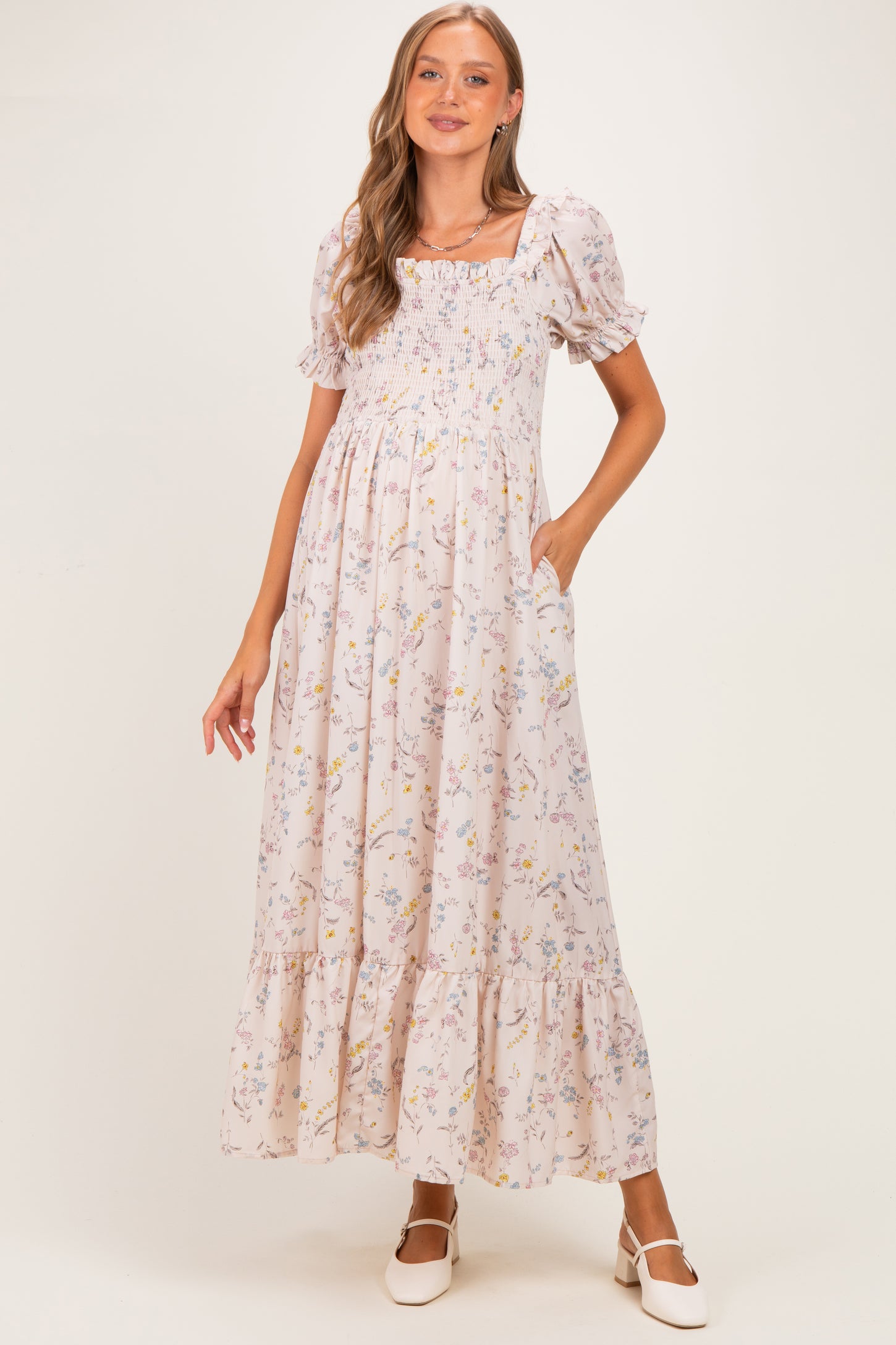 woman wearing a floral print maternity maxi dress with smocked bodice and puff sleeves