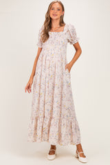 woman wearing a floral print maternity maxi dress with smocked bodice and puff sleeves