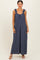 woman wearing a navy blue sleeveless maxi dress with ruffled straps and a flowy fit