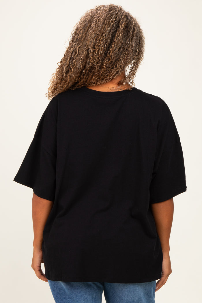 woman wearing a black oversized t-shirt with a relaxed fit and rolled sleeves, seen from the back