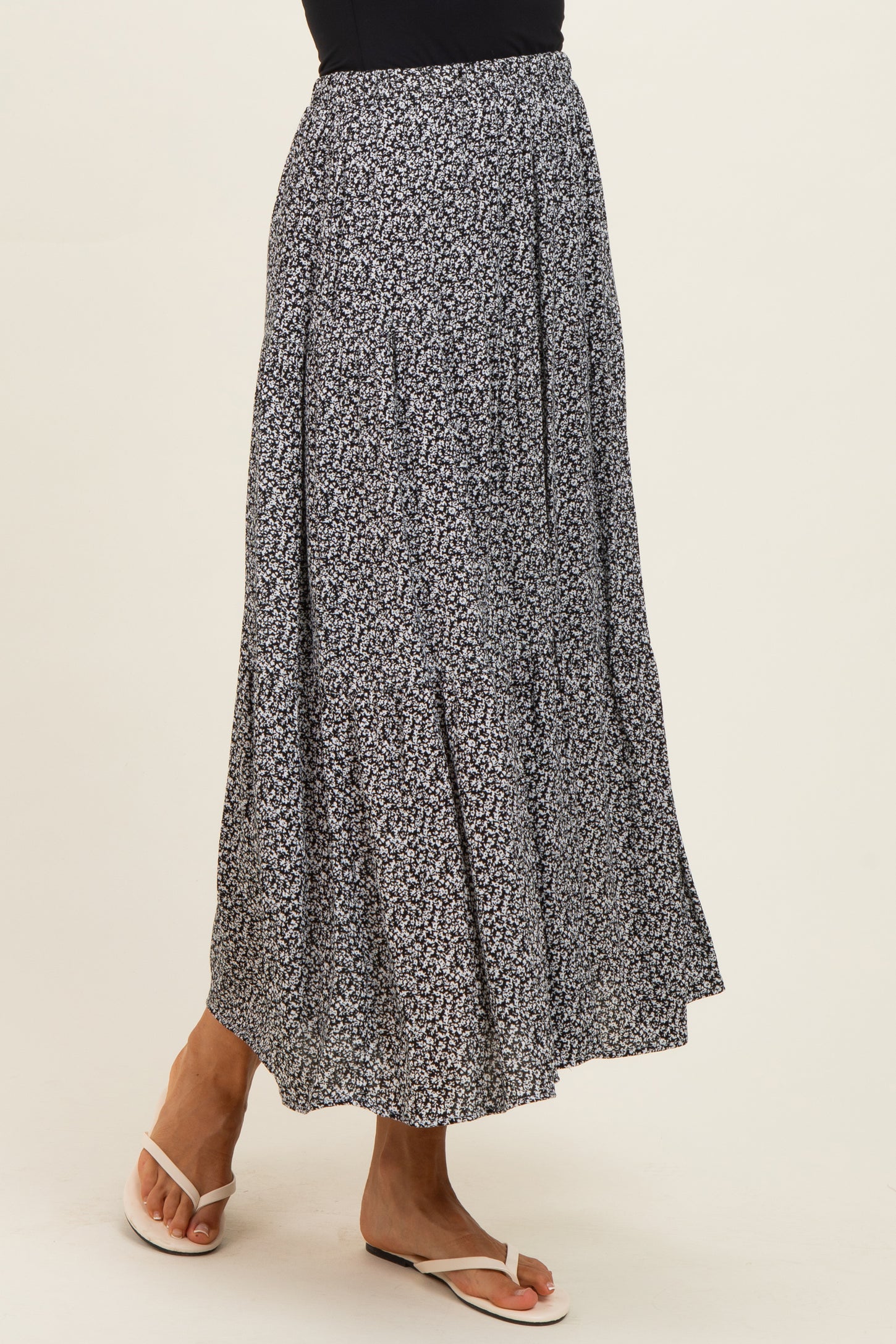 woman wearing a navy blue floral maxi skirt with a flared design and a comfortable fit