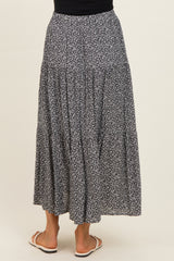 woman wearing a black and white floral maxi skirt, viewed from the back, with a flared hem and elastic waist