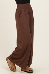 woman wearing brown wide-leg pants with a smocked waistband and side pockets