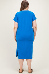 woman wearing a blue maternity plus dress with short sleeves and a back slit, showing her baby bump from the back