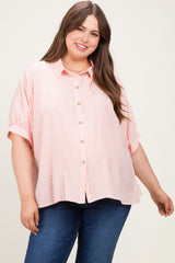 woman wearing a pink and white striped maternity button-up shirt with a relaxed fit and short sleeves