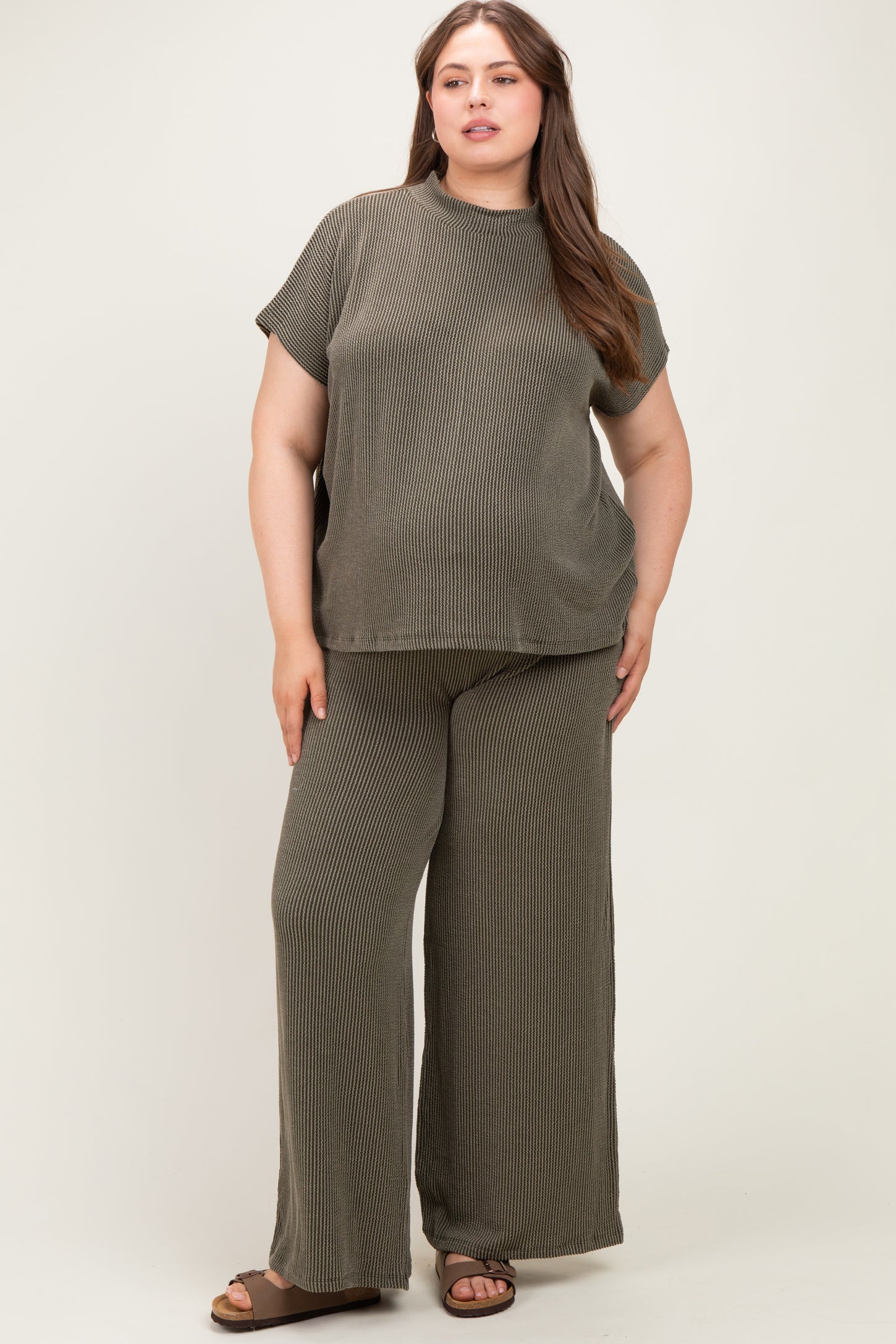 woman wearing a dark olive green ribbed maternity plus size lounge set with short sleeves and wide-leg pants