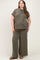 woman wearing a dark olive green ribbed maternity plus size lounge set with short sleeves and wide-leg pants