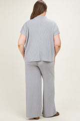 woman wearing a light gray and white striped maternity plus outfit with a loose fit top and wide-leg pants, seen from the back
