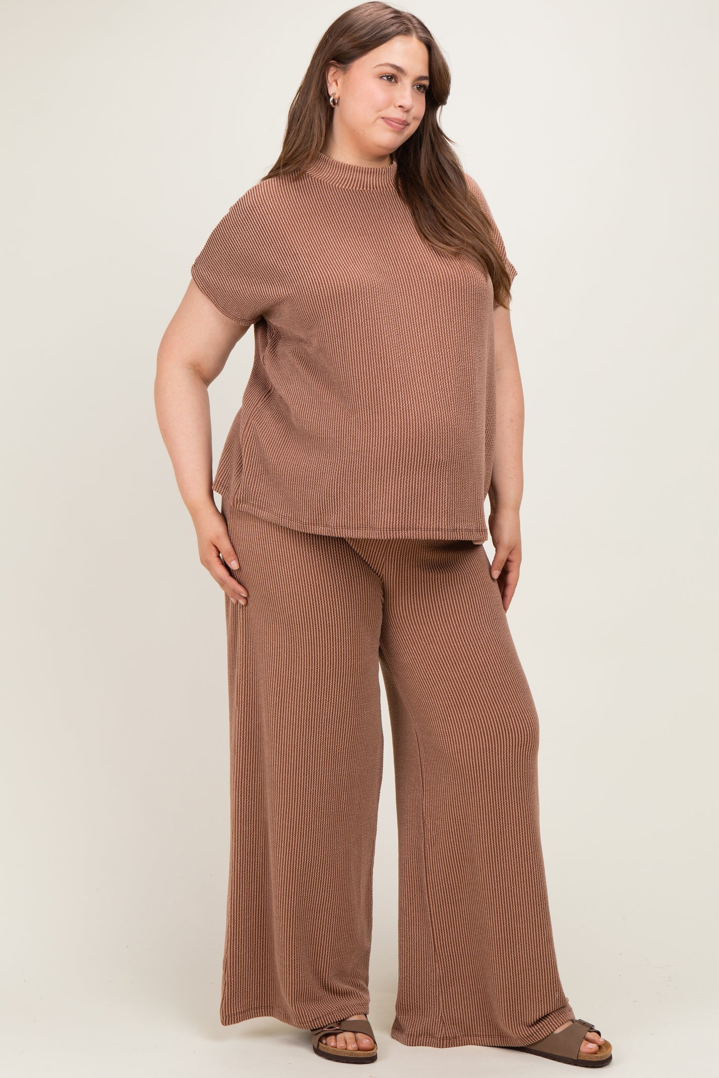 woman wearing a brown ribbed maternity plus top and wide-leg pants with a visible baby bump