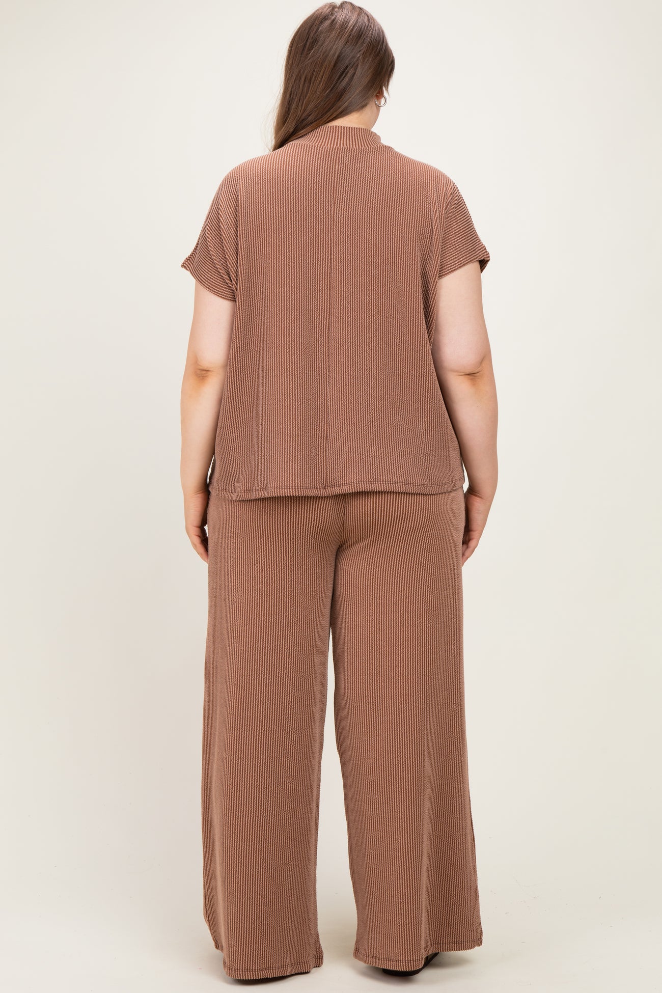 woman wearing a brown ribbed maternity plus lounge set, showing the back view of the top and wide-leg pants