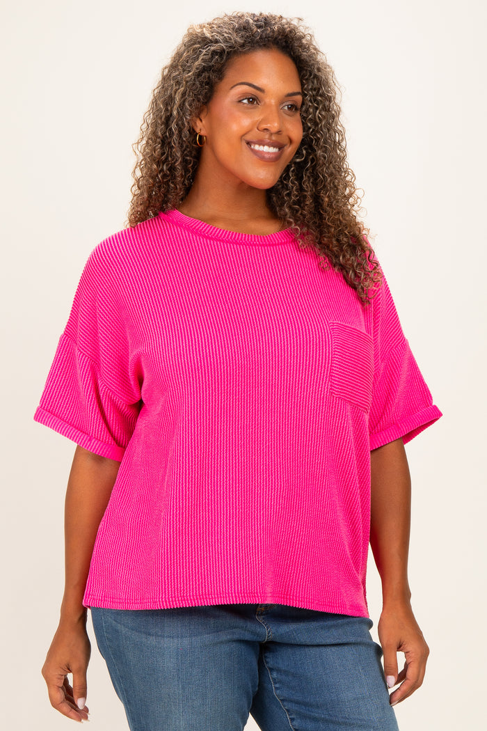 woman wearing a bright pink plus size ribbed t-shirt with short sleeves and a front pocket
