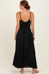 woman wearing a black maxi dress with spaghetti straps and a cinched waist, shown from the back