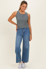 woman wearing a gray ribbed tank top with button details and high-waisted blue wide-leg jeans