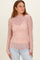 woman wearing a pink long sleeve lace top with a high neckline and a fitted silhouette, styled with light blue jeans