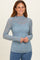 woman wearing a light blue long sleeve lace top with a high neckline and slim fit