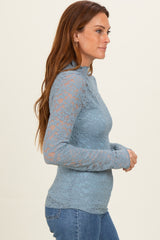 woman wearing a light blue lace long sleeve top with a fitted silhouette and round neckline
