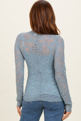 woman wearing a blue lace long sleeve top, shown from the back with floral lace pattern and fitted style