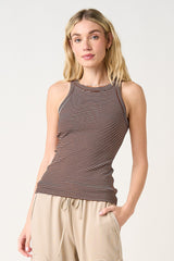 woman wearing a brown and cream striped fitted tank top with a high neckline and athletic style