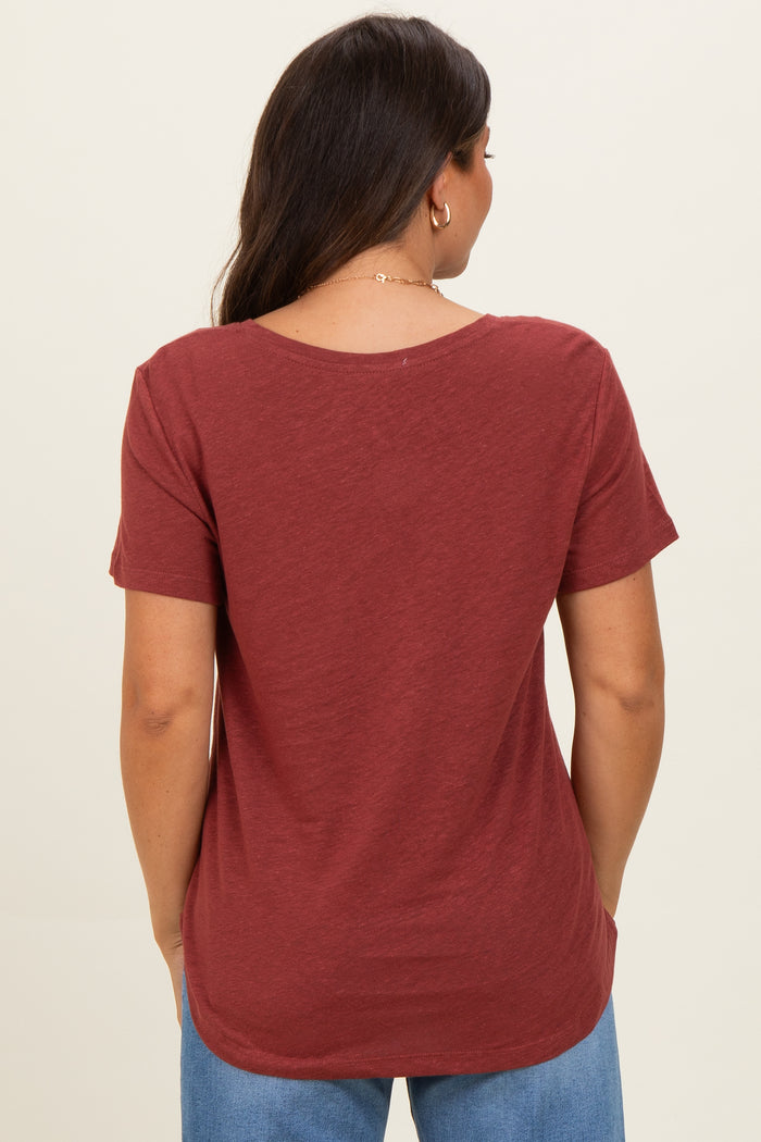 woman wearing a rust-colored short sleeve maternity top seen from the back
