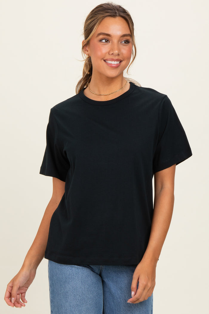 woman wearing a black short sleeve t-shirt paired with high-waisted light blue jeans.