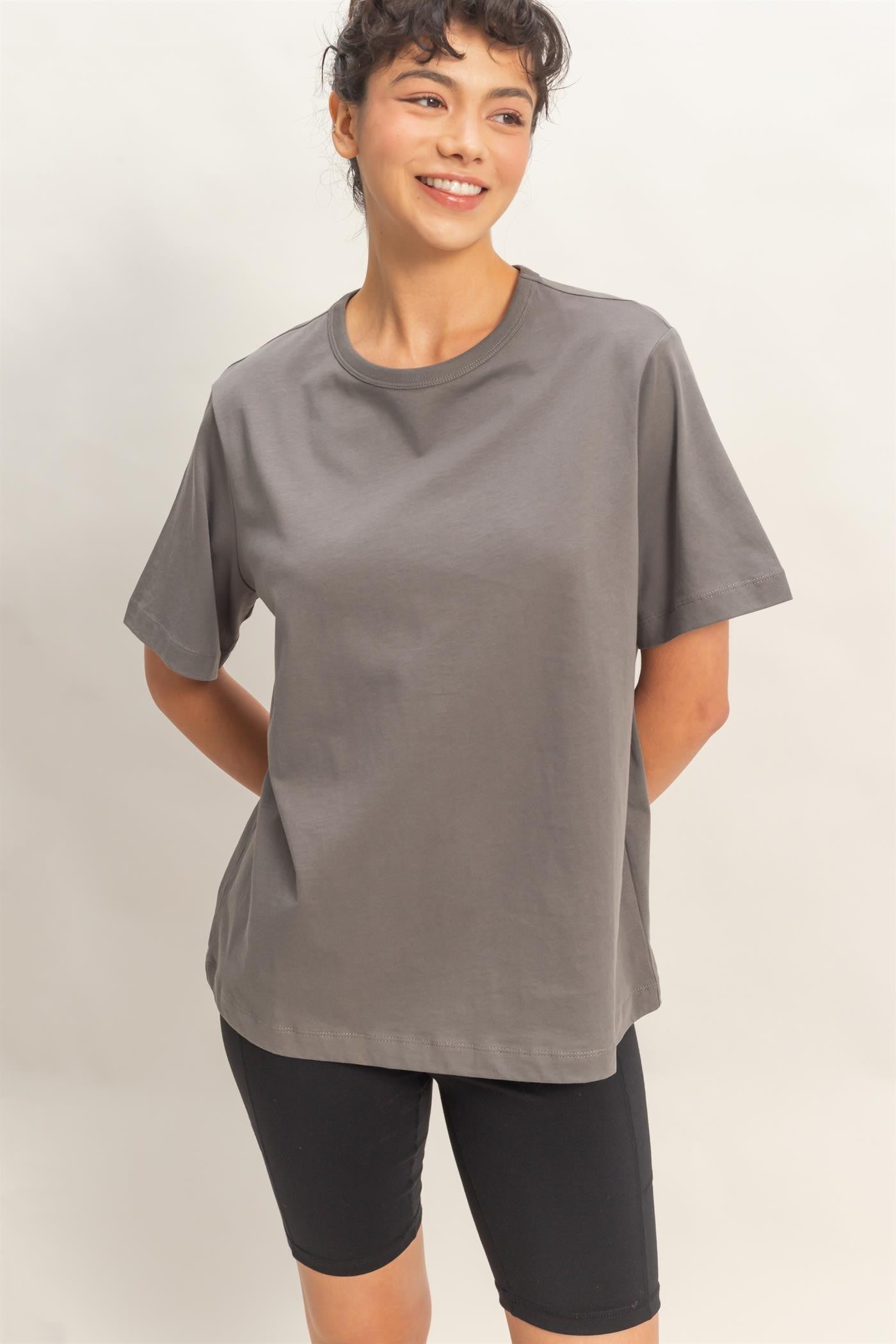 woman wearing a gray short sleeve t-shirt paired with black bike shorts