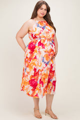 woman wearing a floral maternity plus dress with an empire waist and pockets, showcasing her baby bump