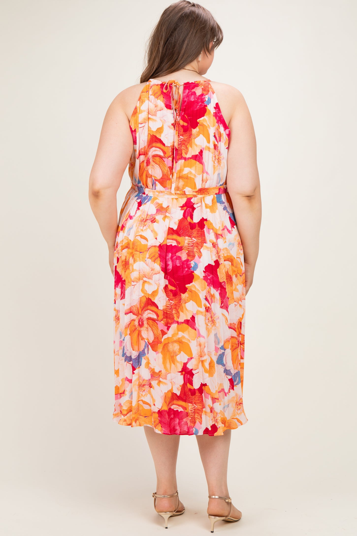 woman wearing a floral midi maternity dress with a tie-back detailing and a flowing silhouette, view from the back