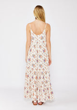 woman wearing a floral maxi dress with thin straps and a tiered hem, viewed from the back