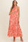 woman wearing a red floral print maternity maxi dress with a halter neckline and holding her baby bump